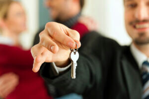 close on time with oz lending man holding a house key after closing on his mortgage loan